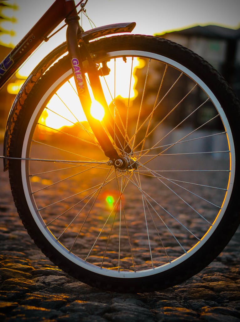 Close-up of a bicycle wheel with sunlit spokes on a cobblestone street in Ethiopia.