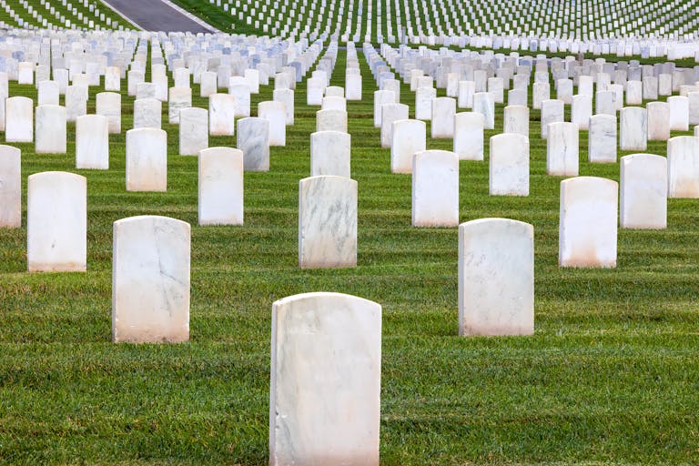 Quiet moment captured at a military cemetery with aligned white tombstones on green grass.