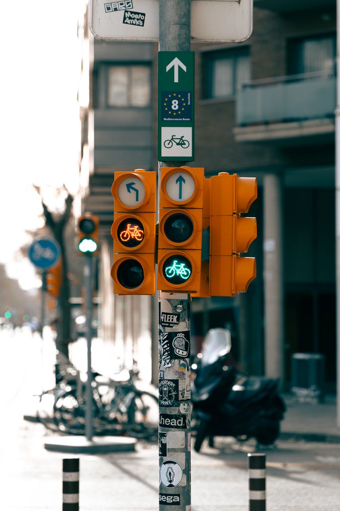 Bicycle traffic light on a sunny Barcelona street promoting cycling infrastructure.